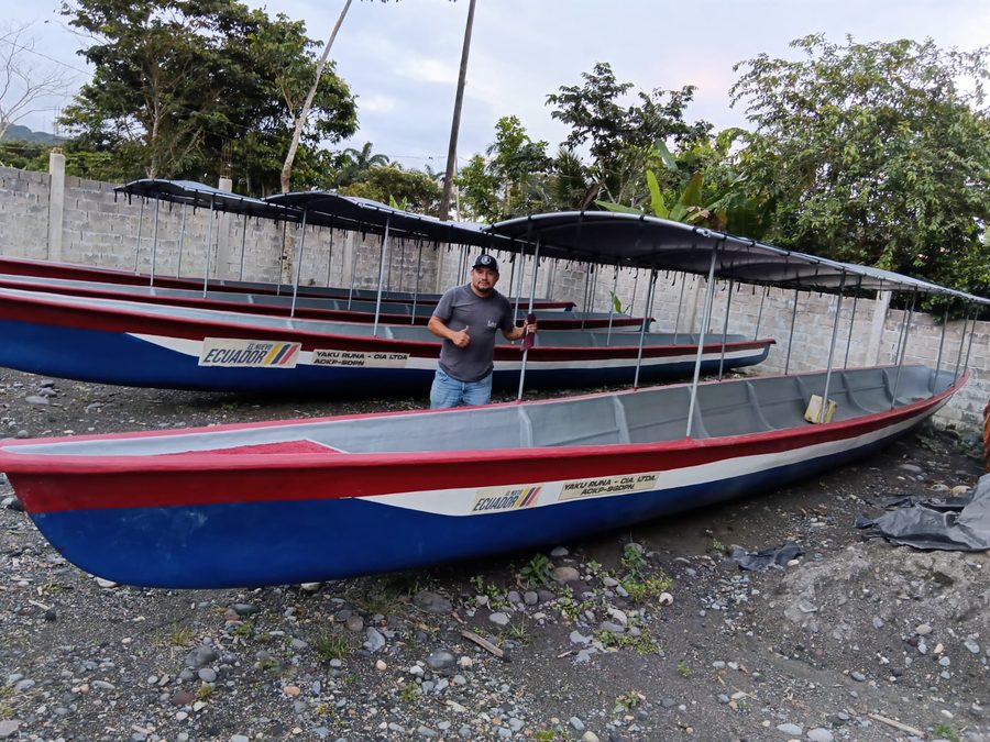 Flota de canoas de YAKU RUNA con toldo, listas para zarpar, junto a un tripulante